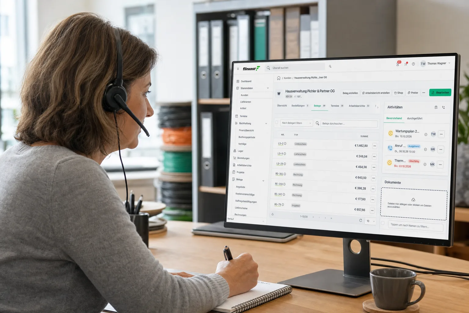 Mitarbeiterin im Büro telefoniert mit Headset, auf dem Monitor die Kundenakte einer Hausverwaltung mit Belegen und offenen Aufgaben